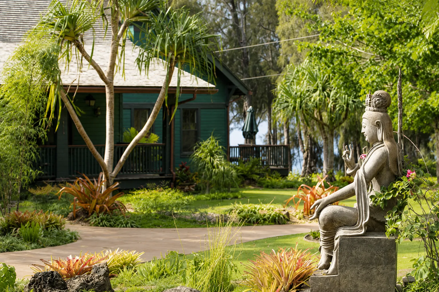 A serene statue surrounded by tropical gardens and historic retreat buildings